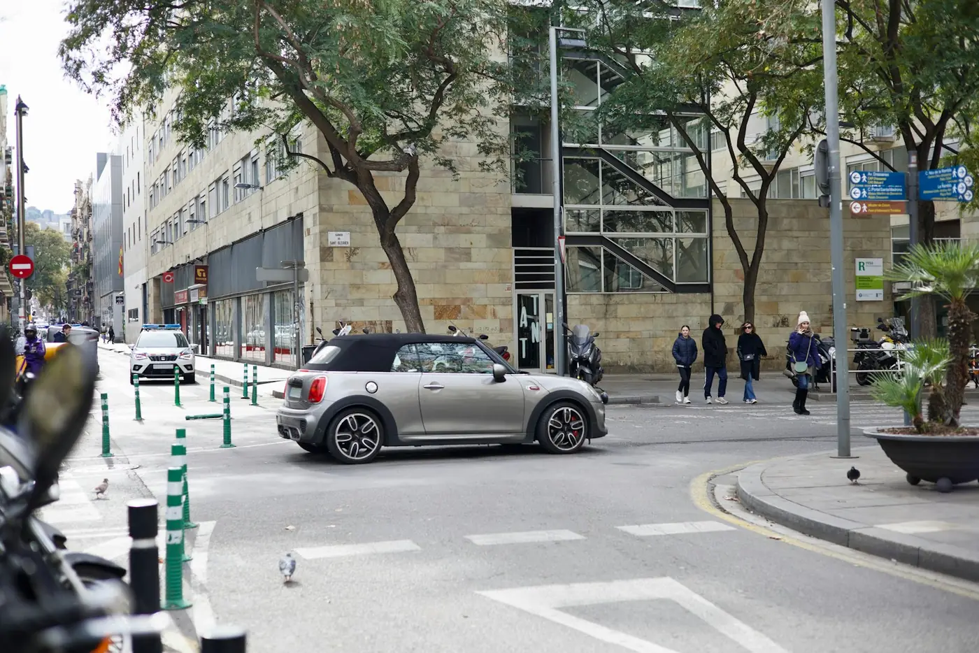 רחוב בברצלונה עם מכוניות חונות ועוברי אורח על המדרכה, ספרד, באור יום