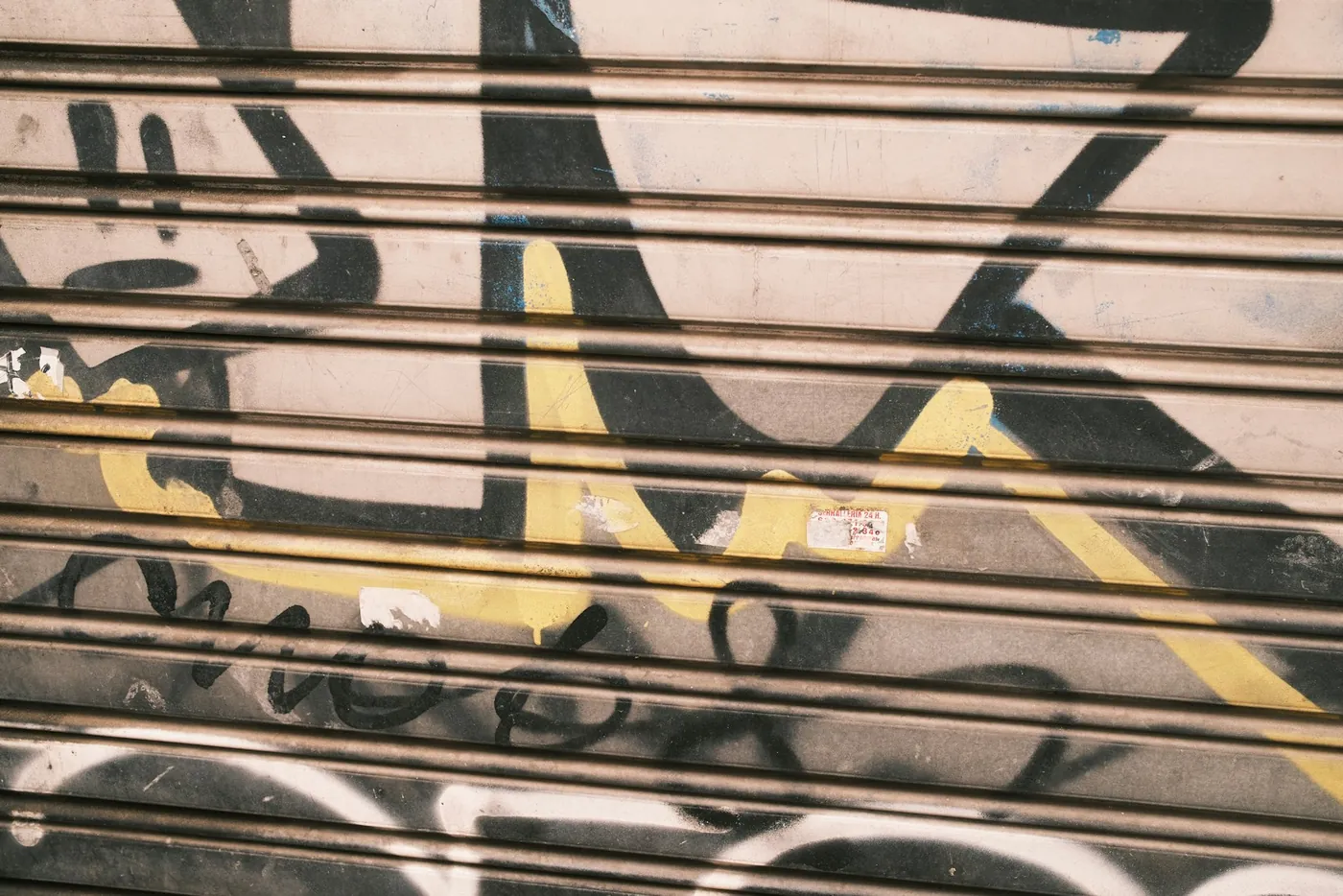 תריס מתכת סגור של חנות ברחוב מואר שמש בברצלונה, אור יום