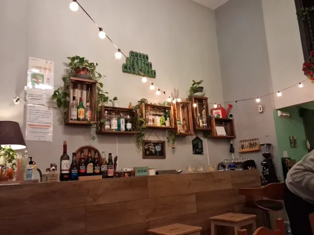 דלפק עץ בהיר, ארגזים תלויים עם בקבוקים וצמחים ושרשרת נורות