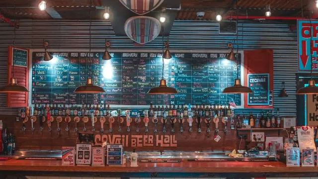 בר עם שורת ברזים ארוכה ולוחות גיר של תפריט מעל, קיר פח גלי