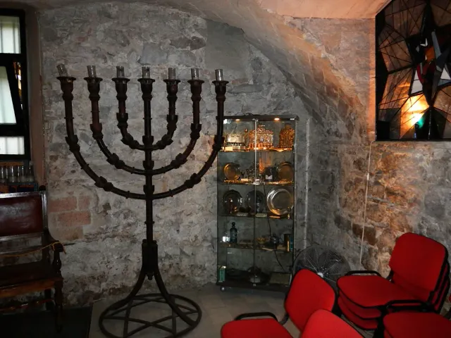חלל אבן קטן ומקומר עם מנורה גדולה וויטרינת תצוגה מוארת