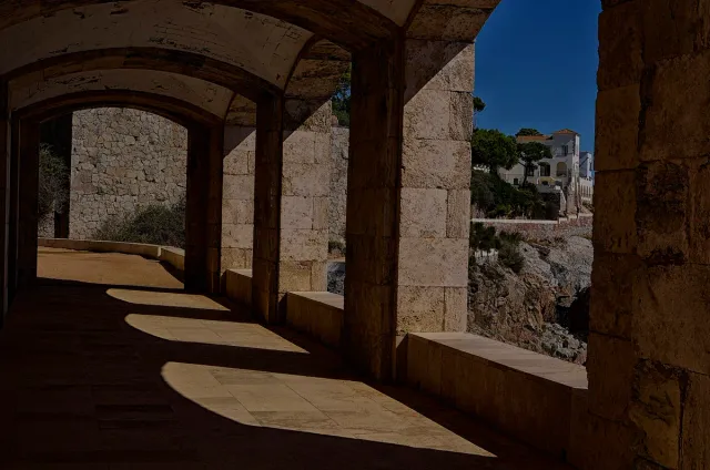 מעבר אבן מקורה עם קשתות שנפתחות אל הים