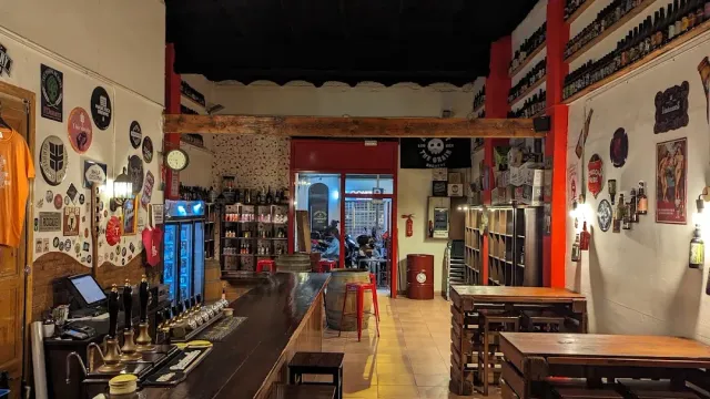 בר עץ עם ברזים, קירות מכוסים תוויות בירה ושולחנות עץ בהמשך