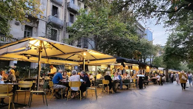 שורת שמשיות צהובות מוארות עם סועדים רבים בשעת בין הערביים